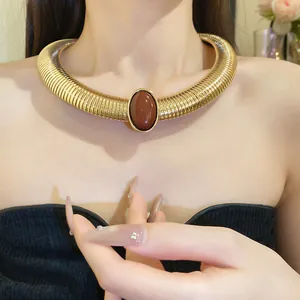 Close-up of a vintage gold metallic choker necklace with a brown oval resin center.
