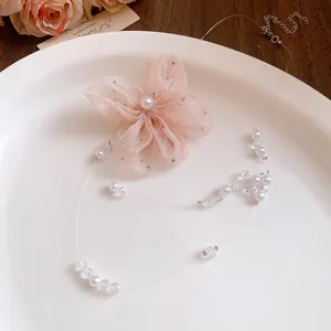 Close-up view of a light pink chiffon flower necklace with elegant pearl beads and crystals