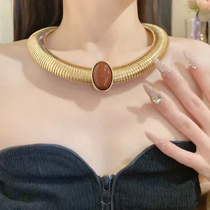 Close-up of vintage court style gold metal collar necklace with oval resin stone
