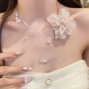 Close-up detail shot of elegant chiffon flower necklace with pearl beads on model