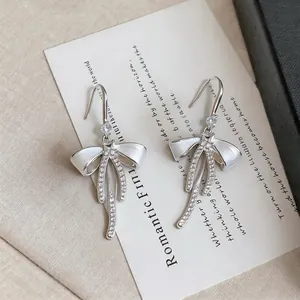 Dettaglio di eleganti orecchini a fiocco in argento con scintillanti strass francesi