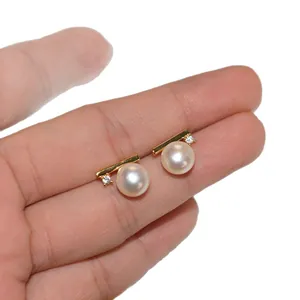 Korean style minimalist pearl stud earrings with zircon held in hand for scale