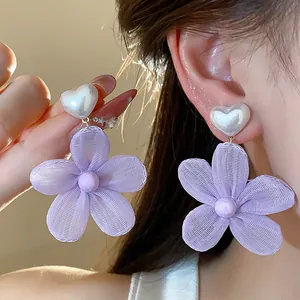 Dettaglio ravvicinato degli orecchini a fiore in chiffon viola e perla a cuore