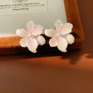 Detailed macro view showing the pink shimmer enamel flower earrings with a zircon center