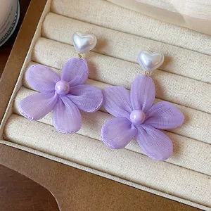 Dettaglio degli orecchini a fiore in chiffon viola con perla a forma di cuore