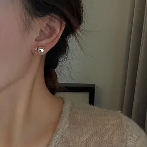 Close-up detail of a minimalist Korean style earring with pearl and zircon inlay