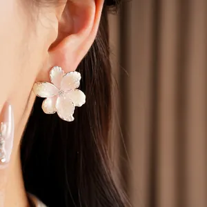 Close-up showing the intricate detail of a pink flower earring with zircon stone