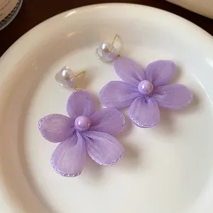 Eleganti orecchini a perno con fiori di chiffon lilla e perle a cuore su piatto