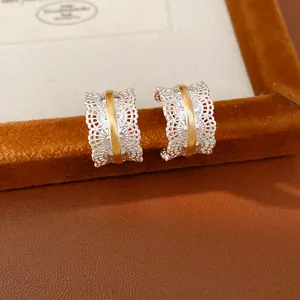 Elegantes pendientes en forma de C con textura de encaje y raya dorada en caja.