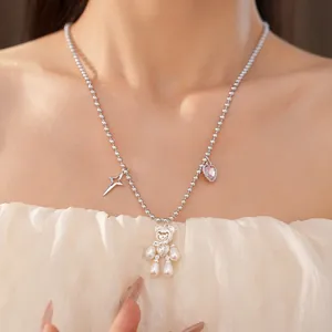 Close-up of cute pearl bear necklace with zircon heart and star charms on model