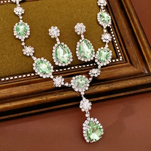 Close-up of elegant court style jewelry set with light green gemstones and rhinestones.