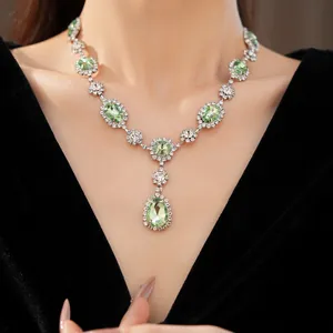 Detail view of palace style necklace featuring green teardrop gems and rhinestones