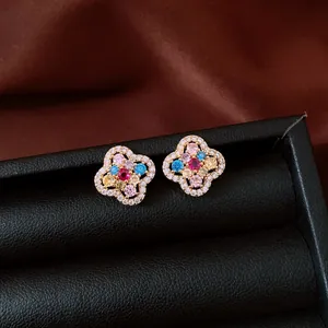 Close-up detail of 14k gold plated flower stud earrings with colorful cubic zirconia