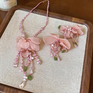 Elegant pink fabric flower jewelry set including a floral necklace and stud earrings