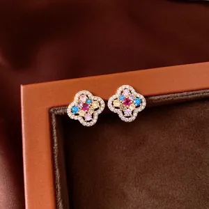 Detailed close-up of 14k gold plated flower stud earrings with colorful zircons