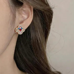 Close-up detail of 14k gold plated vintage flower earrings with multi-color zircons