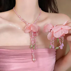 Detailed macro view of elegant pink fabric flower necklace and earring set on model