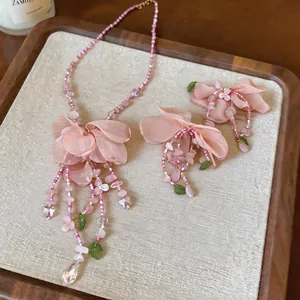 Elegant detailed view of a handmade dusty rose fabric flower and beaded jewelry set