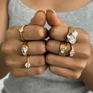 Detailansicht mehrerer goldener Titanstahlringe mit klaren Zirkonia-Steinen.