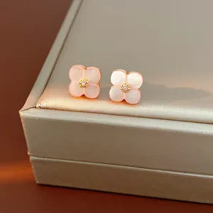 Dettaglio di orecchini a lobo a fiore rosa ciliegio con centro in zircone dorato