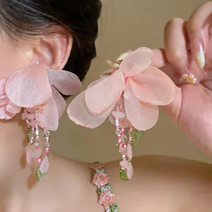 Detailed view of pink fabric flower earrings with delicate beads and crystal accents