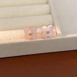 Primo piano di eleganti orecchini a lobo a forma di fiore rosa con zircone incastonato al centro