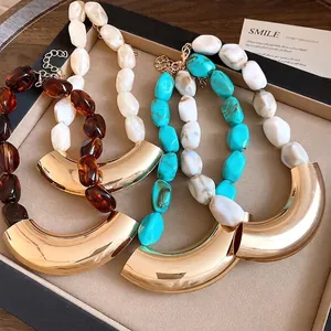 Vintage acrylic beaded necklaces with large curved gold pendants set in tray