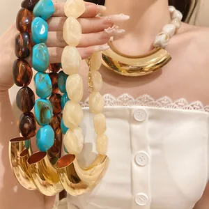 Macro view of chunky acrylic beads and polished gold horn pendant on a vacation necklace