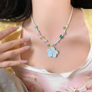 Close-up of dopamine style blue flower pendant necklace with colorful star beads.