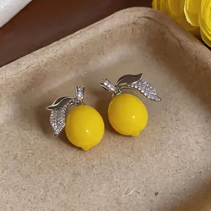 Exquisite micro-pave zircon lemon stud earrings for a stylish summer vacation look.
