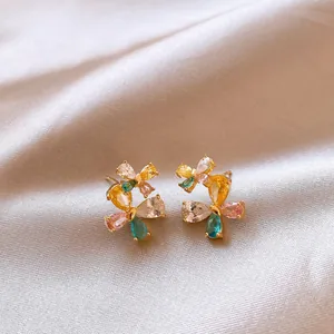 Detailed close-up of vibrant butterfly stud earrings with colorful teardrop zirconia on satin