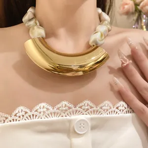 Close-up view of a vintage chunky acrylic bead necklace with a curved gold metal pendant