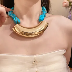 Detail shot of vintage acrylic beaded necklace with curved gold metal pendant
