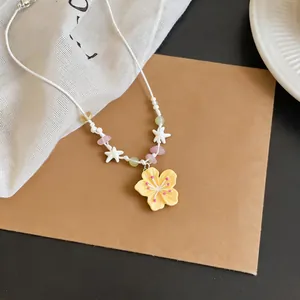 Detailed view of a cute dopamine-style necklace featuring a yellow flower pendant