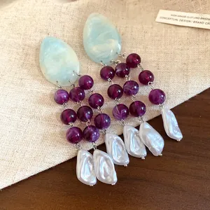 Detailed view of vintage resin and pearl tassel earrings featuring blue marble texture and purple beads