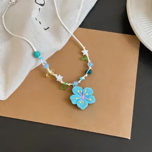 Detailed view of light blue flower pendant necklace with colorful beads and white star charms.