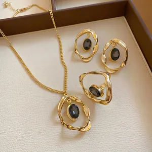 Vintage gold jewelry set featuring oval dark gemstones and unique crumpled metal frames