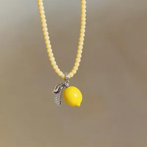 Close-up of summer lemon pendant necklace with yellow beads and micro-pave zircon leaves