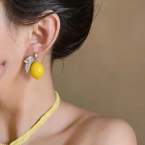 Detailed close-up of yellow lemon stud earrings featuring sparkling micro-set zircons
