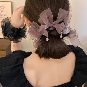Vue détaillée d'un élégant chouchou en mousseline avec perles de cristal sur cheveux sombres