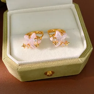Dettaglio degli orecchini a stella in zircone rosa in una scatola di gioielli in velluto verde
