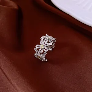 Nahaufnahme eines funkelnden Zirkonia-Blumenrings mit gelben Mittelsteinen im Detail