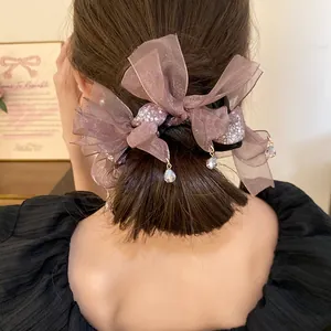 Gros plan d'un chouchou élégant en mousseline violette avec pendentifs en cristal.