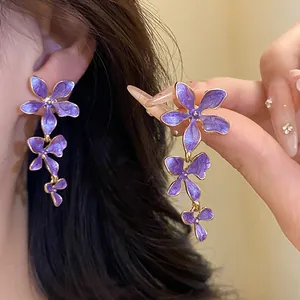 Detail der lila Emaille-Blumenquastenohrringe mit einem glänzenden Schimmereffekt.