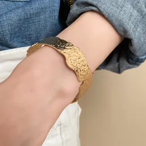 Detailed view of gold hammered open cuff bracelet with wavy irregular edges