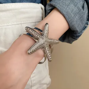 Detailed view of a silver oversized starfish-shaped open cuff bracelet for women
