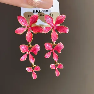 Detailansicht der pinkfarbenen Emaille-Blumen-Ohrhänger mit glitzerndem Goldrand