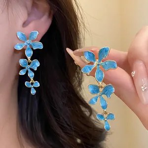 Detaillierte Makroaufnahme der blauen Öl-Tropfen-Blumen-Quastenohrringe mit Goldrand