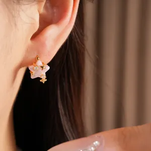Dettaglio di un orecchino a stella rosa con zirconi e finiture dorate.