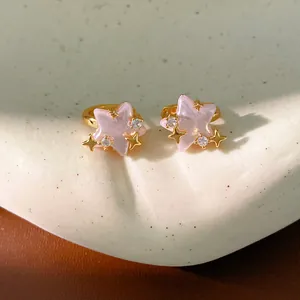 Primo piano dettagliato di orecchini a cerchio in oro con stelle rosa e zirconi per donne.